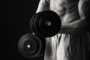 Dambıllarla egzersiz yapan adam.