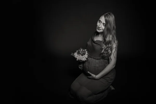 Pregnant woman with flowers — Stock Photo, Image