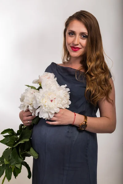 Pregnant woman with bouqet of flowers — Stock Photo, Image