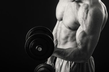 Dambıllarla egzersiz yapan adam.