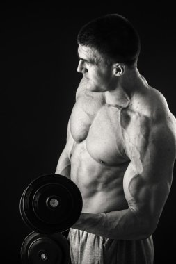 Dambıllarla egzersiz yapan adam.