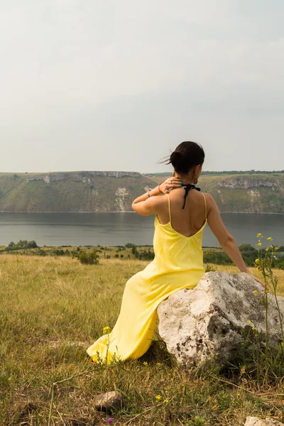 Brunetka w pięknej sukience na brzegu rzeki — Zdjęcie stockowe