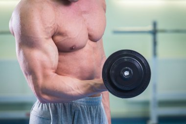 Atlet egzersizleri spor salonunda gerçekleştirir.