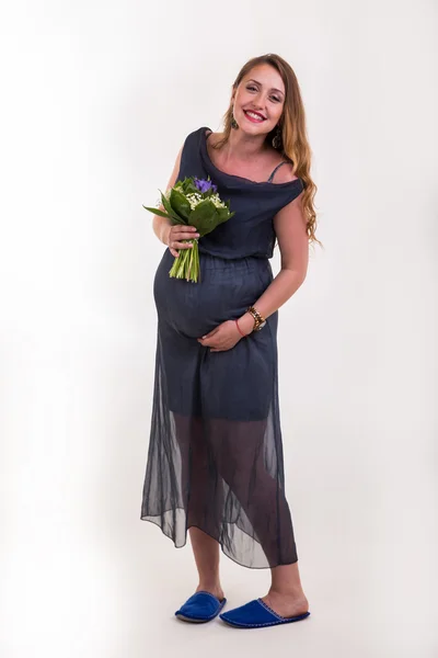 Красивая беременная с цветами — стоковое фото