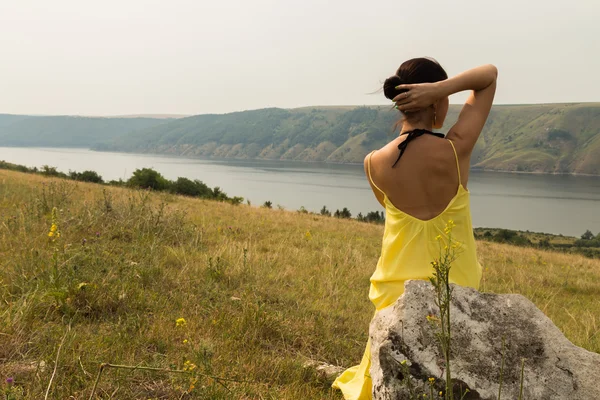 Nehir üzerinde şık sarı elbiseli güzel esmer