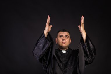 Aktör bir rahip rol oynamaktadır