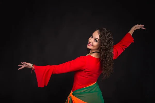 Prachtige vrouw in het rood op een zwarte achtergrond — Stockfoto