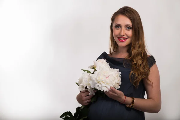 Mooie zwangere vrouw met bloemen — Stockfoto