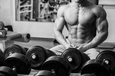 Dambıllarla egzersiz yapan adam.