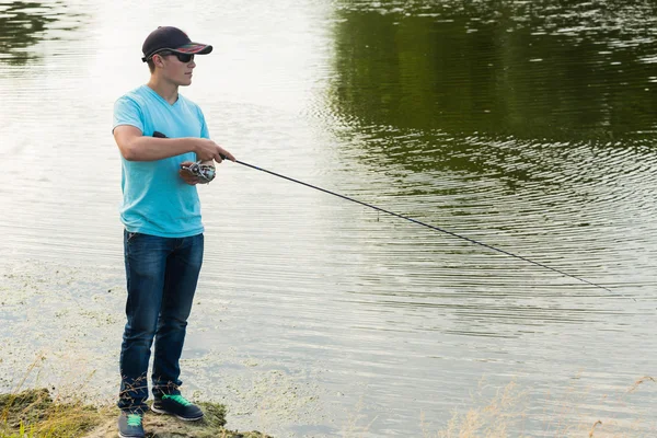 Uomo pesca con una canna da pesca — Foto Stock