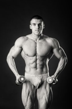 Dambıllarla egzersiz yapan adam.