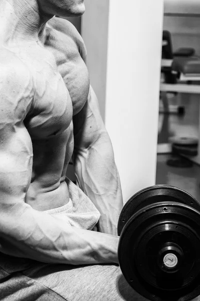 Homem musculoso trabalhando com halteres — Fotografia de Stock