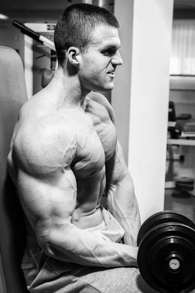 Muscular man working out with dumbbells — Stock Photo, Image