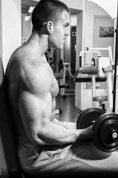 Homem musculoso trabalhando com halteres — Fotografia de Stock