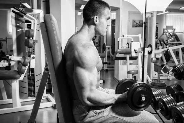 Homem musculoso trabalhando com halteres — Fotografia de Stock