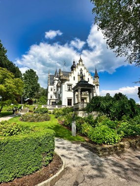 Gotik tarzı şapel ve güller parçalı bulutlu bir gökyüzünün altında çiçek açıyor..