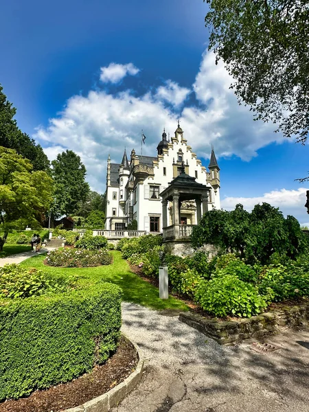 Gotik tarzı şapel ve güller parçalı bulutlu bir gökyüzünün altında çiçek açıyor..