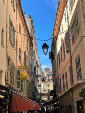 Colorful European square with a statue, fountain and traditional buildings under a blue sky.