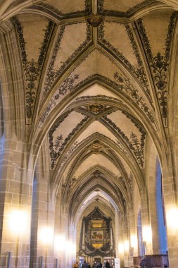 Kubbeli tavanı ve vitray pencereleri olan gotik bir kilisenin önünde..