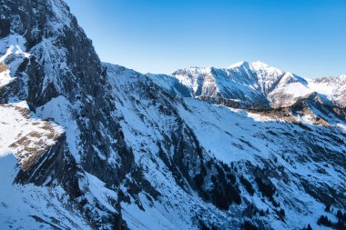 Karlı tepeleri olan geniş dağ manzarası.