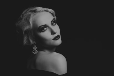 Karanlık bir arka plan üzerinde vintage elbiseli güzel sarışın