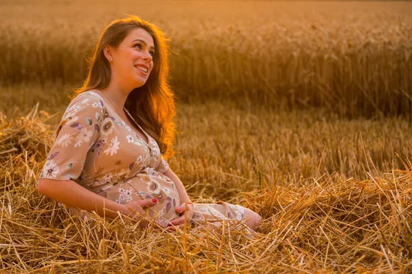 Belle femme enceinte sur une promenade dans un champ de blé — Photo