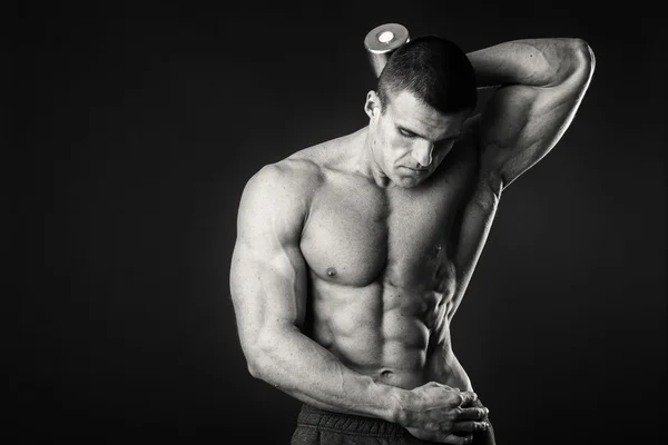 Professional bodybuilder shows his body on a dark background — Stock Photo, Image