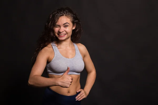 A bela menina de esportes em um fundo escuro — Fotografia de Stock