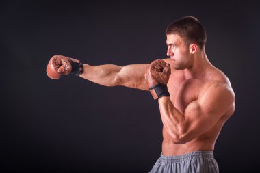 Profesyonel vücut geliştirmeci bedeni koyu arka plan üzerinde gösterir.