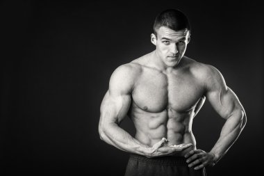 Profesyonel vücut geliştirmeci bedeni koyu arka plan üzerinde gösterir.