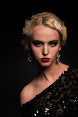 Karanlık bir arka plan üzerinde vintage elbiseli güzel sarışın