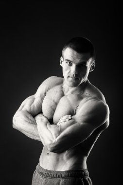 Profesyonel vücut geliştirmeci bedeni koyu arka plan üzerinde gösterir.