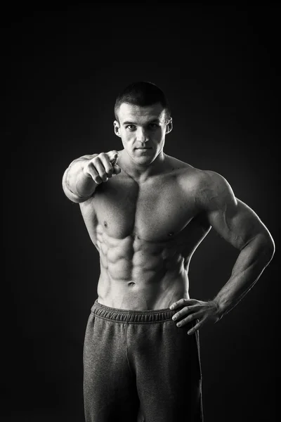 Professional bodybuilder shows his body on a dark background — Stock Photo, Image