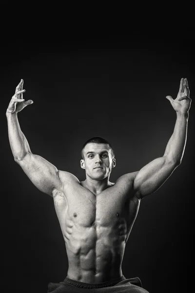 Professional bodybuilder shows his body on a dark background — Stock Photo, Image