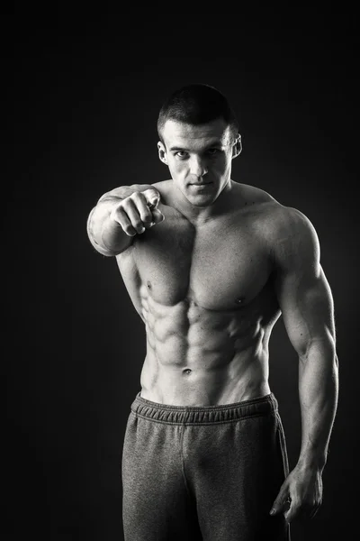 Professional bodybuilder shows his body on a dark background — Stock Photo, Image