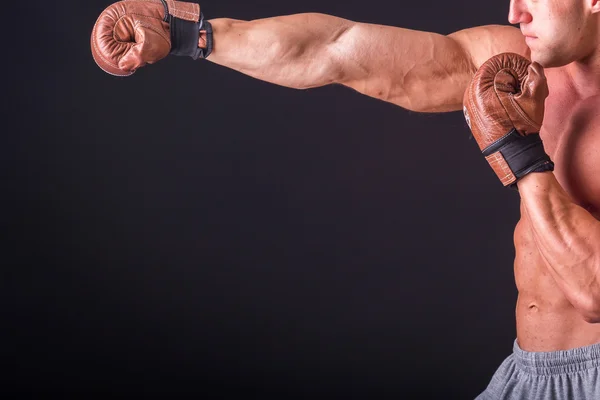 Muscular man in a sports jacket on a dark background — Stock Photo, Image