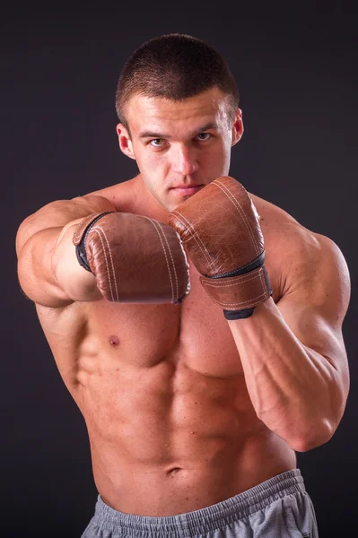 Muscular man in a sports jacket on a dark background — Stock Photo, Image