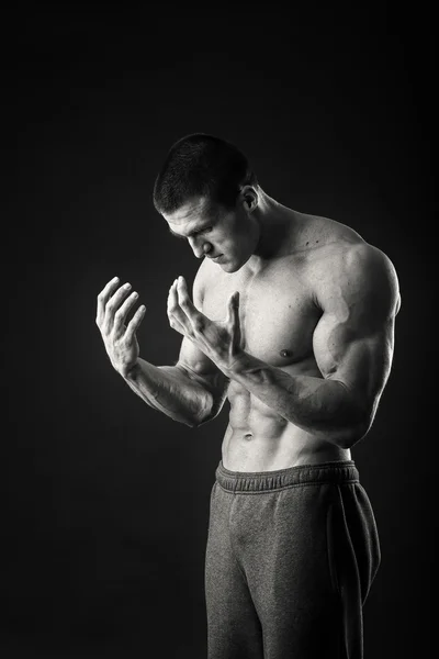 Professional bodybuilder shows his body on a dark background — Stock Photo, Image