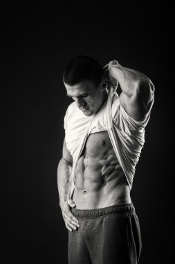 Karanlık bir arka plan üzerinde bir spor ceketli kaslı adamı