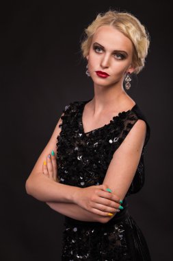 Karanlık bir arka plan üzerinde vintage elbiseli güzel sarışın