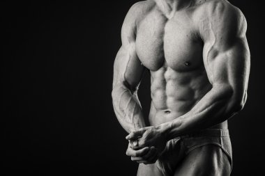 Profesyonel vücut geliştirmeci bedeni koyu arka plan üzerinde gösterir.