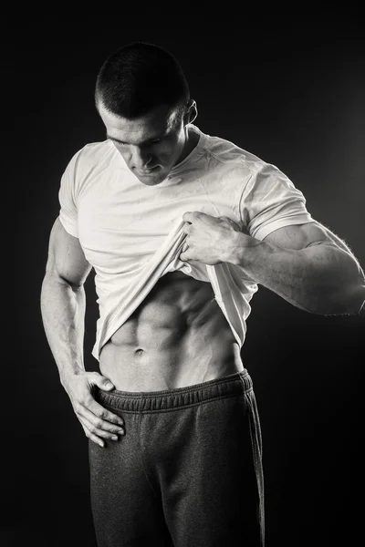 Muscular man in a sports jacket on a dark background — Stock Photo, Image