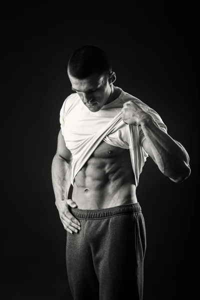 Muscular man in a sports jacket on a dark background — Stock Photo, Image