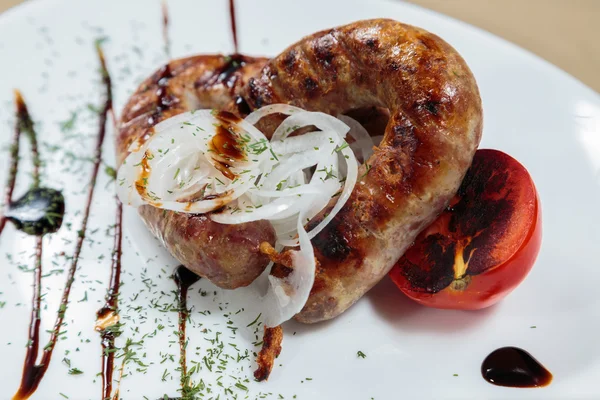 Вкусные баварские сосиски с овощами на белой тарелке — стоковое фото