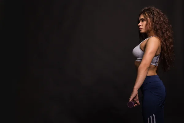 A bela menina de esportes em um fundo escuro — Fotografia de Stock