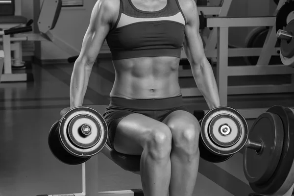 Hermosa chica toma ejercicios en el gimnasio — Foto de Stock