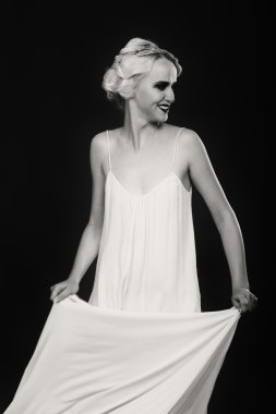 Karanlık bir arka plan üzerinde vintage elbiseli güzel sarışın