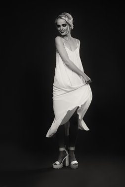 Karanlık bir arka plan üzerinde vintage elbiseli güzel sarışın