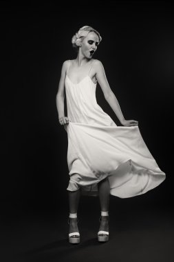 Karanlık bir arka plan üzerinde vintage elbiseli güzel sarışın