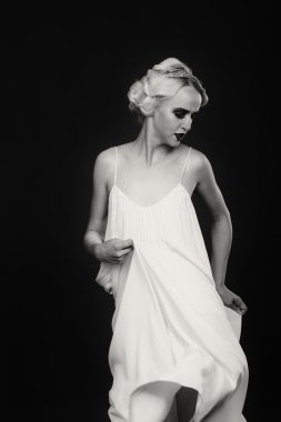 Karanlık bir arka plan üzerinde vintage elbiseli güzel sarışın